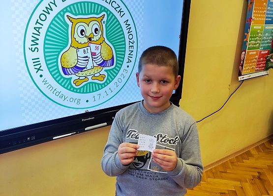 chłopiec stoi przy tablicy multimedialnej