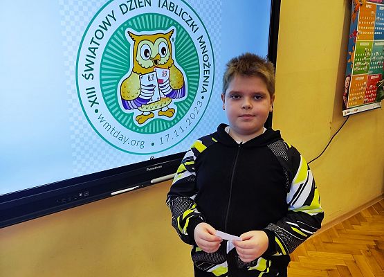 chłopiec stoi przy tablicy multimedialnej