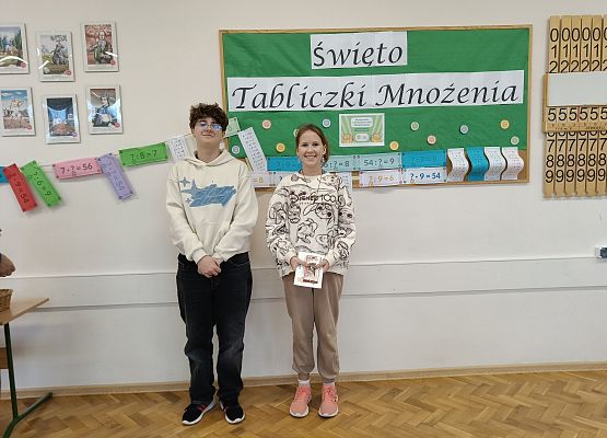 uczniowie stoją  na tle gazetki szkolnej