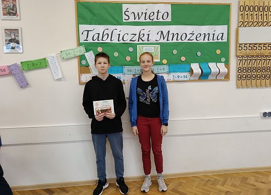 uczniowie stoją  na tle gazetki szkolnej