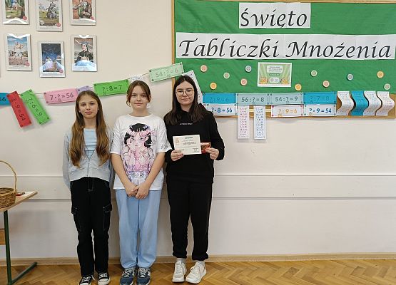 uczniowie stoją  na tle gazetki szkolnej