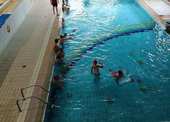 dzieci pływają w basenie