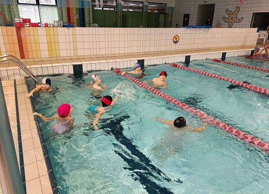 dzieci pływają w basenie