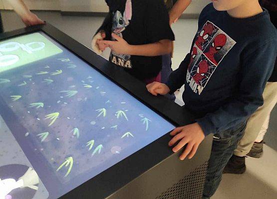 uczniowie oglądają wystawę interaktywną