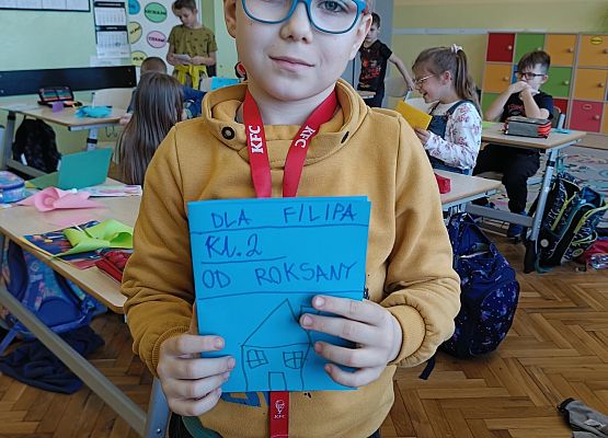 chłopiec prezentuje kartkę z życzeniami