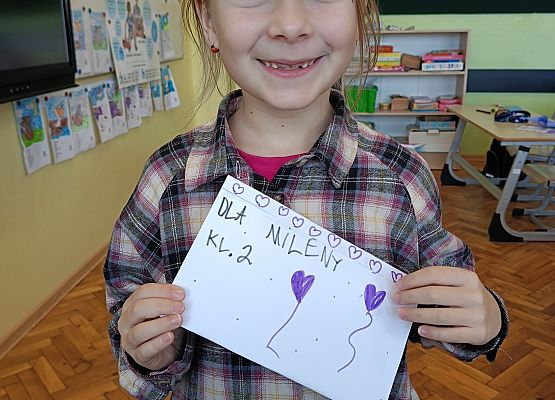 dziewczynka pokazuje życzenia, które otrzymała