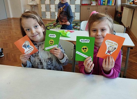 dziewczynki prezentują laurki