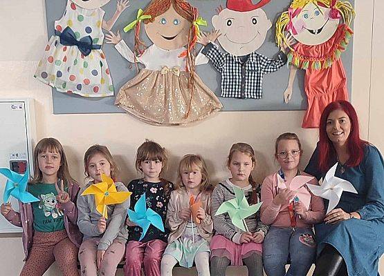 dziewczynki z nauczycielką siedzą na ławce