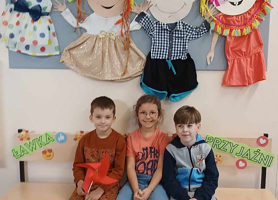 dzieci siedzą na ławce życzliwości