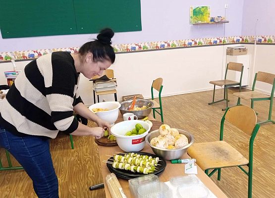 przedstawicielka Rady Rodziców kroi owoce