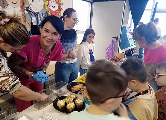 uczniowie i panie z Rady Rodziców przy stoisku z przekąskami