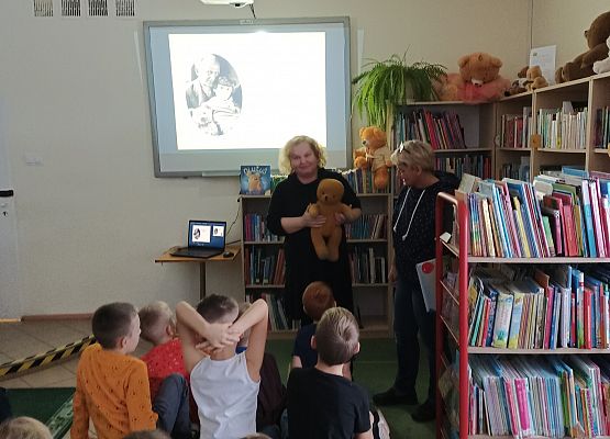 bibliotekarka przedstawia dzieciom misia