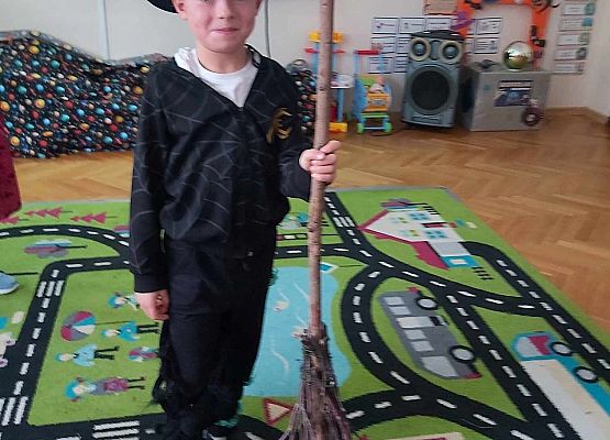 chłopiec trzyma miotłę