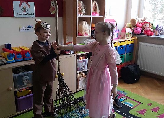dzieci trzymają miotłę