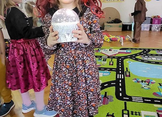 dziewczynka w kolorowym stroju pozuje do zdjęcia