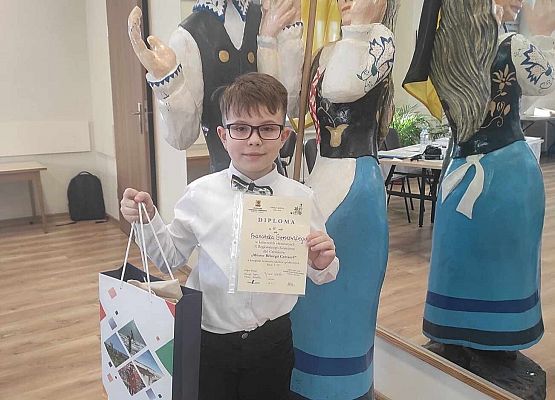 uczeń prezentuje dyplom i nagrodę