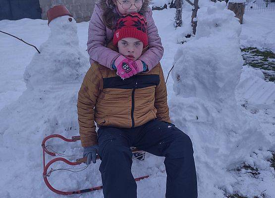 dzieci obok zimowych śnieżnych stworów