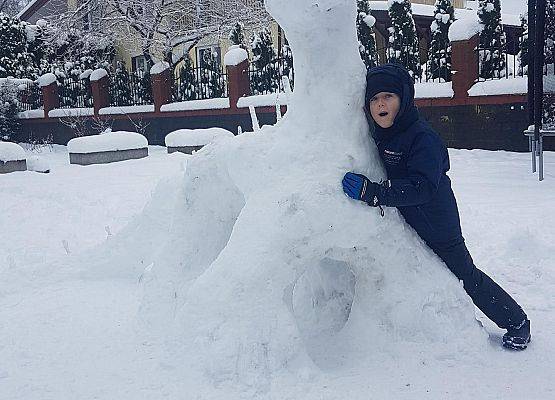 uczeń stoi obok swojego zimowego stwora
