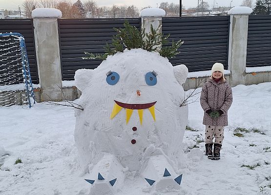 uczennica stoi obok swojego zimowego stwora