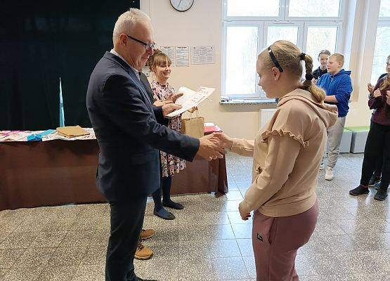 dyrektor wręcza uczennicy nagrodę