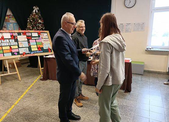 dyrektor wręcza uczennicy nagrodę