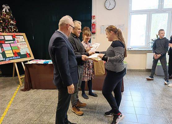 dyrektor wręcza uczennicy nagrodę