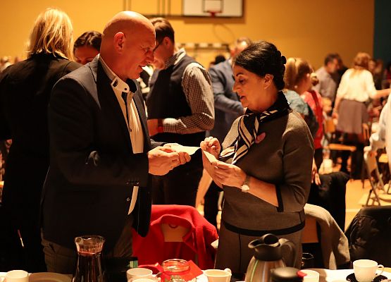 goście składają sobie życzenia i łamią się opłatkiem