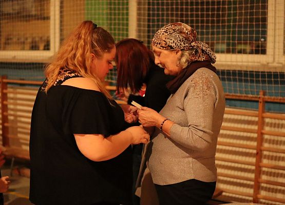 goście składają sobie życzenia i łamią się opłatkiem