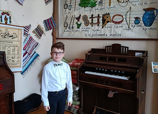 uczeń stoi przy pianinie
