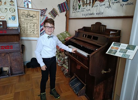 uczeń stoi przy pianinie