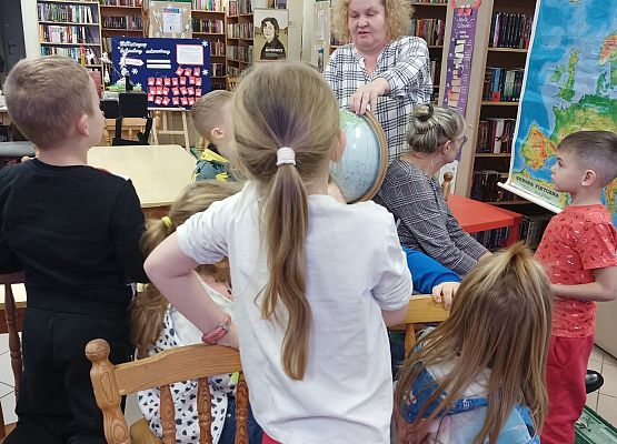 dzieci przyglądają się globusowi