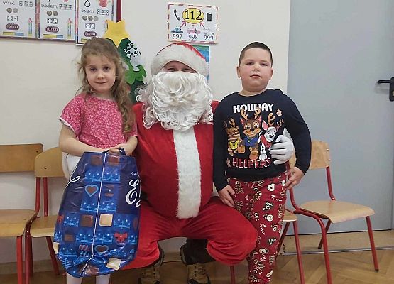 dzieci pozują do zdjęcia z Mikołajem