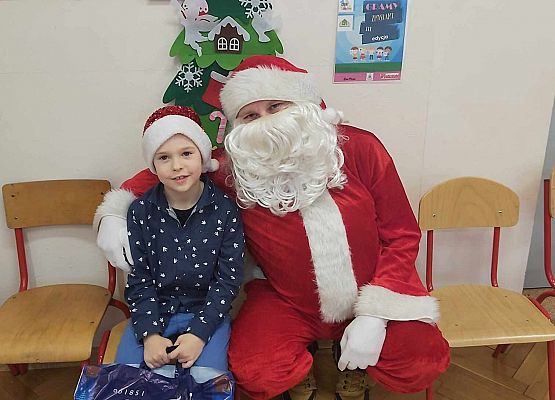 dzieci pozują do zdjęcia z Mikołajem