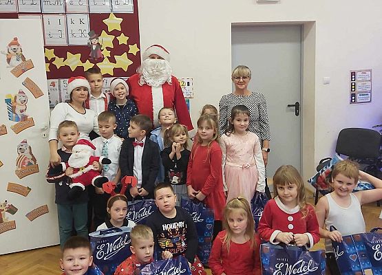 dzieci pozują do zdjęcia z Mikołajem