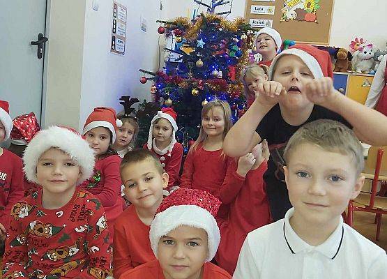 dzieci siedzą przed choinką