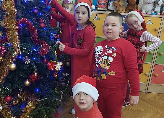 dzieci wieszają ozdoby na choince