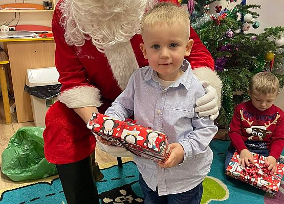 chłopiec odbiera prezent od Mikołaja