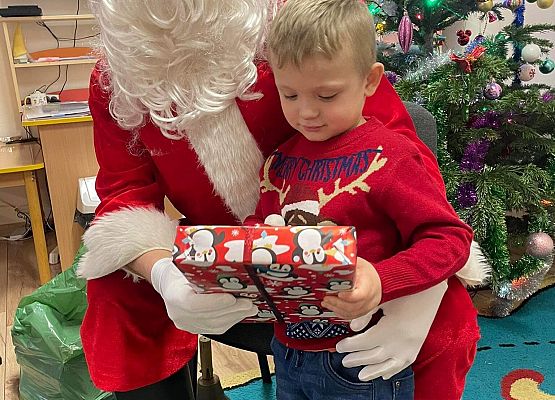 chłopiec odbiera prezent od Mikołaja