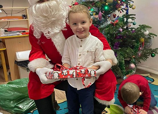 chłopiec odbiera prezent od Mikołaja