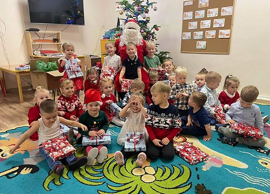 dzieci pozują do zdjęcia z Mikołajem