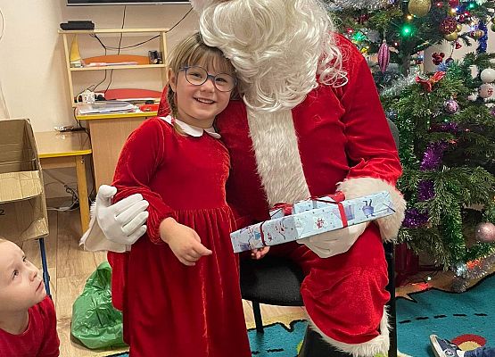 dziewczynka odbiera prezent od Mikołaja