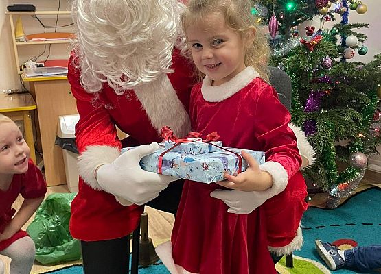 dziewczynka odbiera prezent od Mikołaja