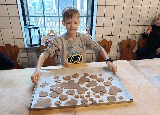 chłopiec trzyma blachę z piernikami