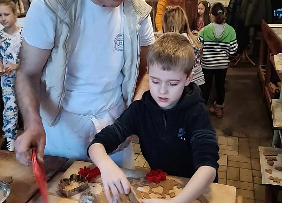 piekarz pomaga uczniowi wykrawać pierniczki