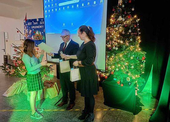 uczennica odbiera nagrodę i dyplom