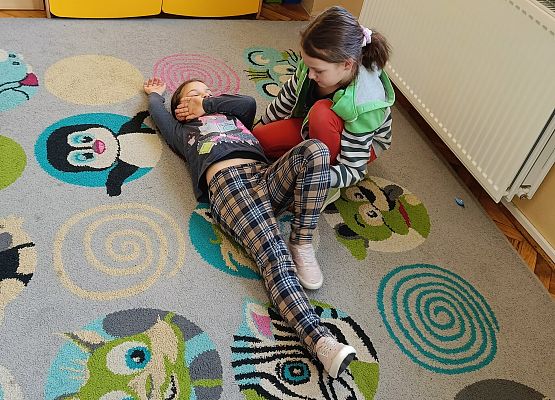 uczniowie układają poszkodowanych w bezpiecznej pozycji