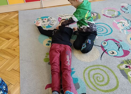 uczniowie układają poszkodowanych w bezpiecznej pozycji