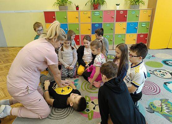 pani pokazuje uczniom, jak należy udzielać pierwszej pomocy przedmedycznej