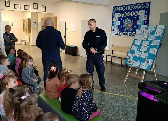 policjanci omawiają z dziećmi zasady bezpieczeństwa podczas ferii
