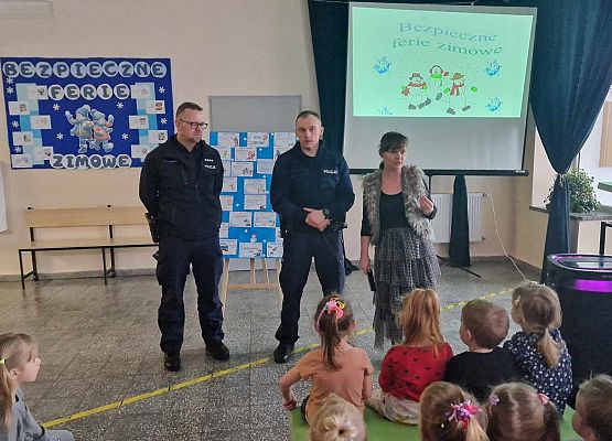 policjanci omawiają z dziećmi zasady bezpieczeństwa podczas ferii